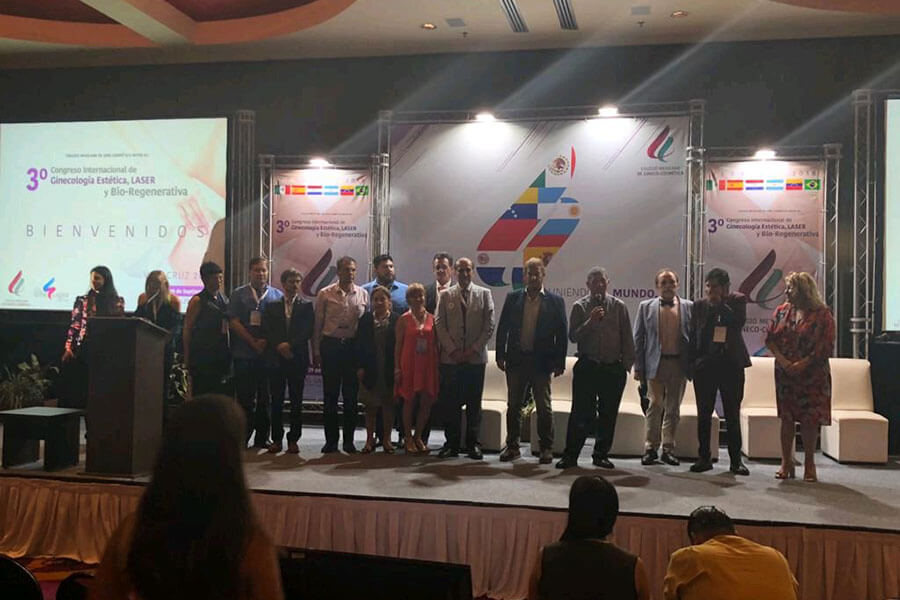Ponentes y organizadores reunidos en el escenario con banderas de países participantes